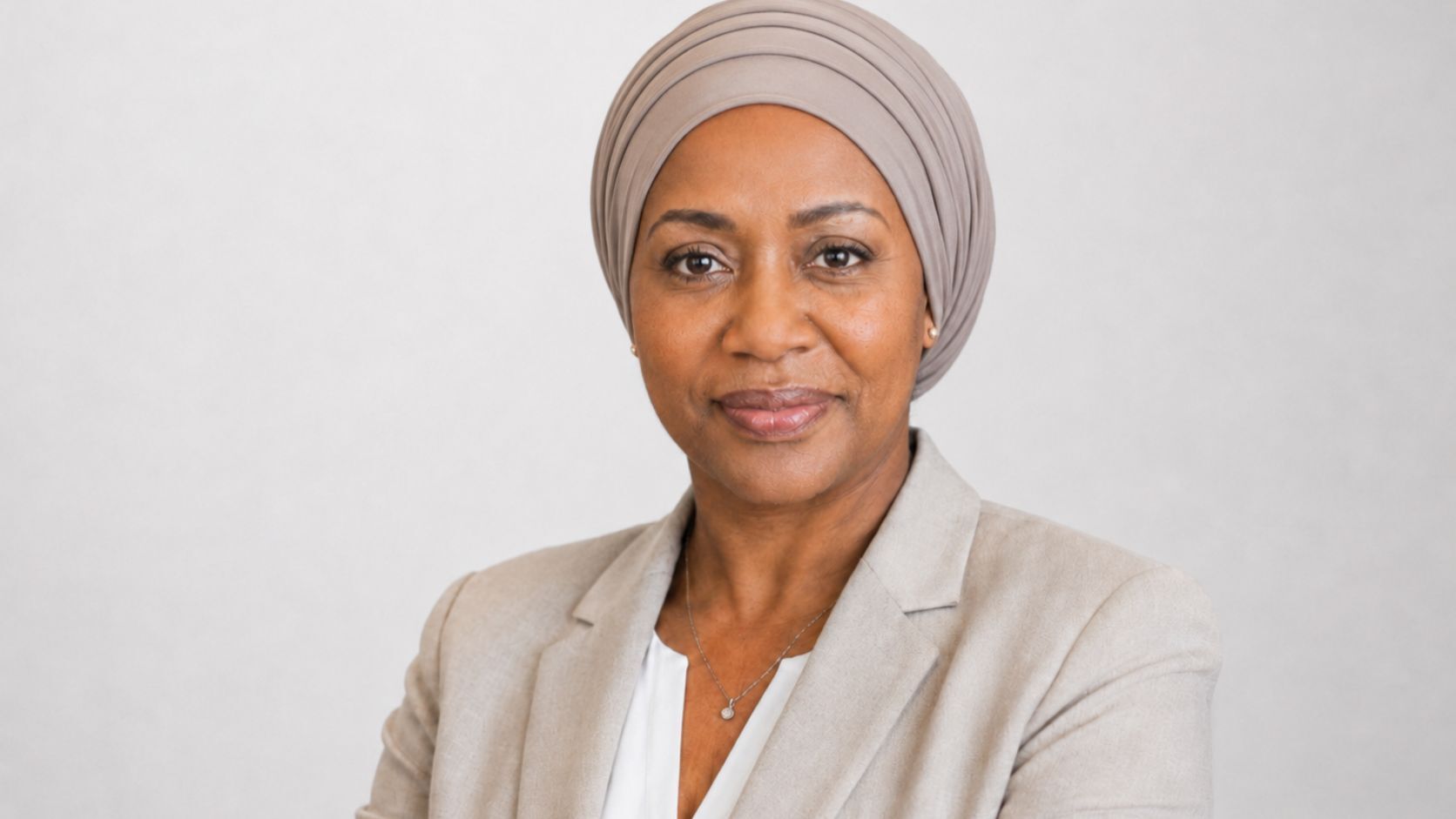 Dr. Maya Carter, Principal AI Strategist at Data Science Consulting Pro, shown in a professional studio headshot with a neutral background and covered hair.